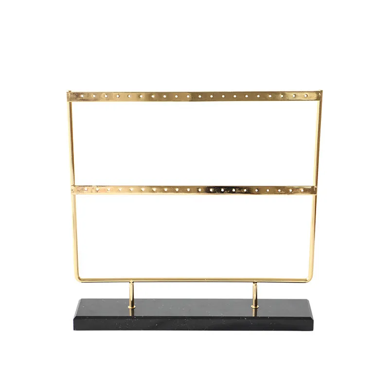 Alloy earring storage rack in green on a desktop holding multiple stud and hook earrings