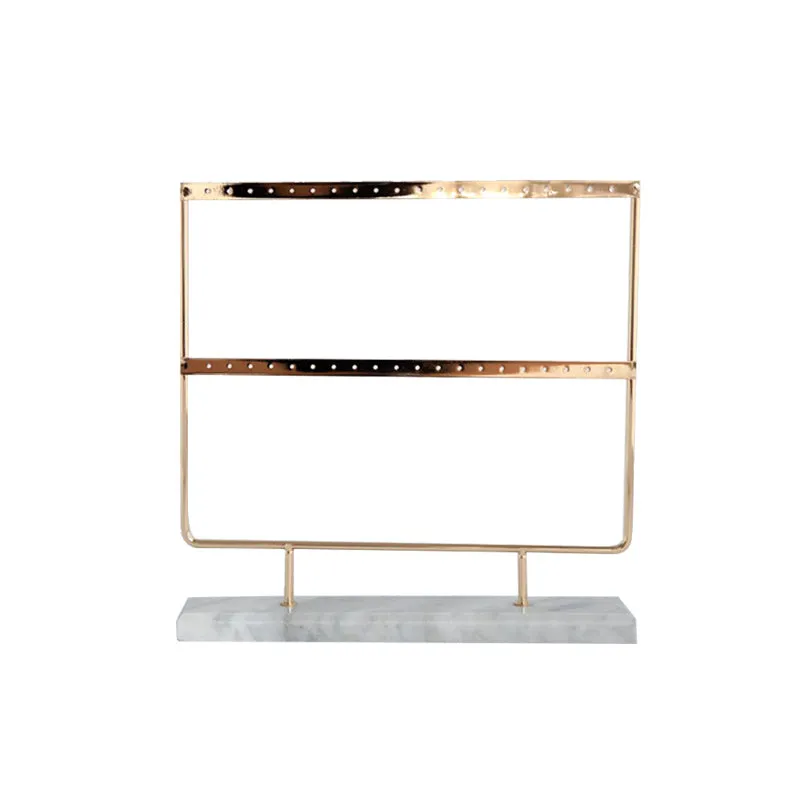 Alloy earring storage rack in green on a desktop holding multiple stud and hook earrings