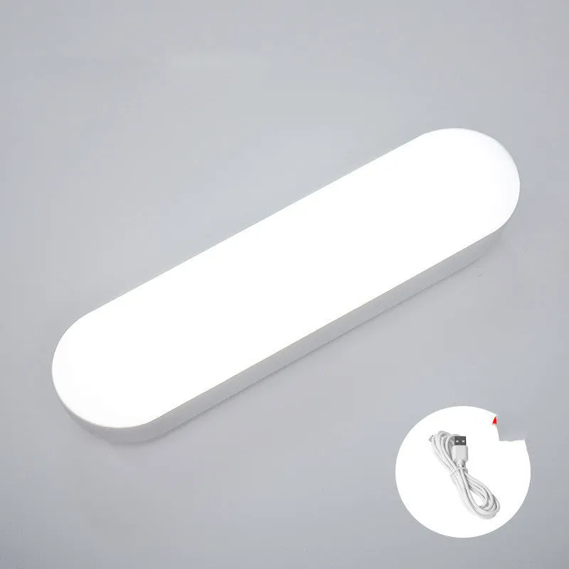 Fully automatic unplugged bedside night light for dormitory with magnetic base, USB rechargeable, showing yellow light mode on a dark bedside table