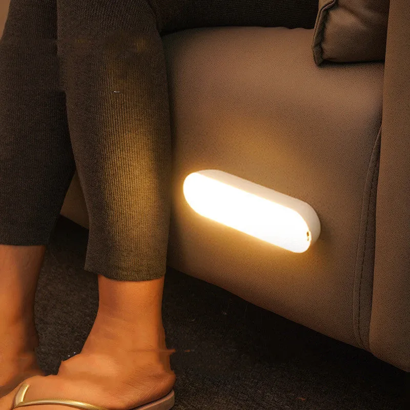Fully automatic unplugged bedside night light for dormitory with magnetic base, USB rechargeable, showing yellow light mode on a dark bedside table