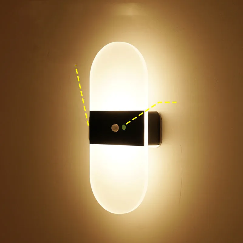 Magnetic rechargeable wall lamp in arc style, black finish, with warm light on a metal bedside shelf