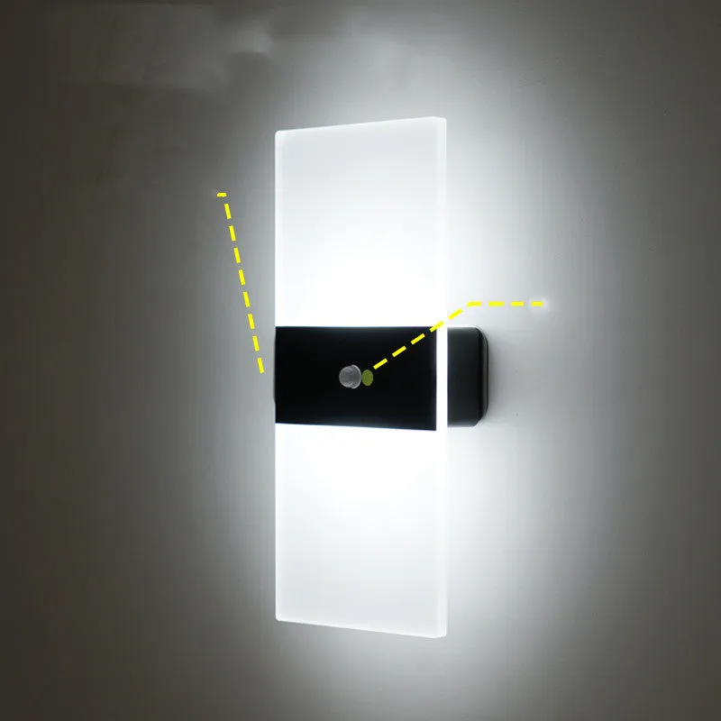 Magnetic rechargeable wall lamp in arc style, black finish, with warm light on a metal bedside shelf