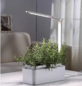 White hydroponic self-absorbent herb vegetable planting box with LED grow lights and water alarm on a desktop