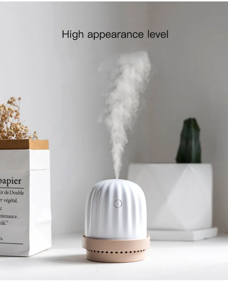Cactus humidifier night light in green with colourful LED glow on a wooden desk
