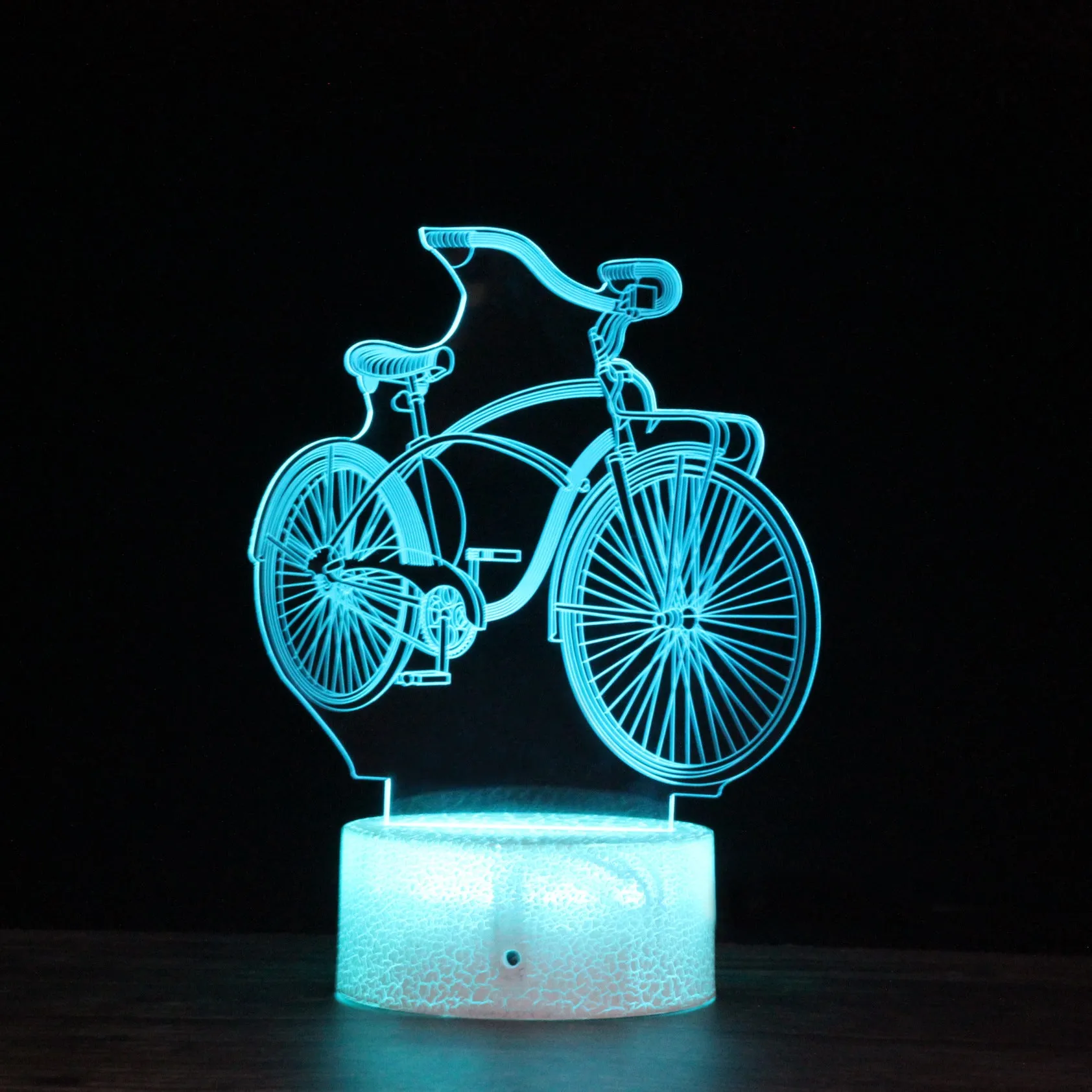 3D bicycle night light with LED acrylic shade on black base against a dark background