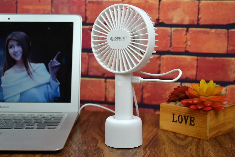 White ORICO FH1 portable USB rechargeable desk fan with three-speed buttons and compact handheld design.
