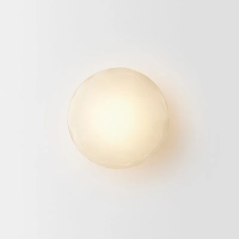 Bedside hotel glass art wall lamp with transparent lampshade and iron body on a wall