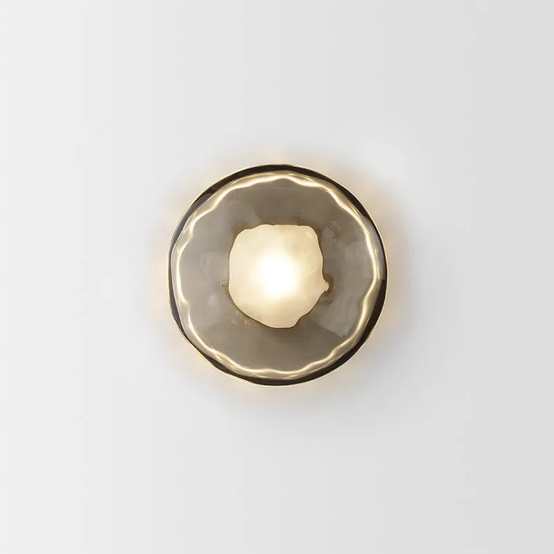 Bedside hotel glass art wall lamp with transparent lampshade and iron body on a wall