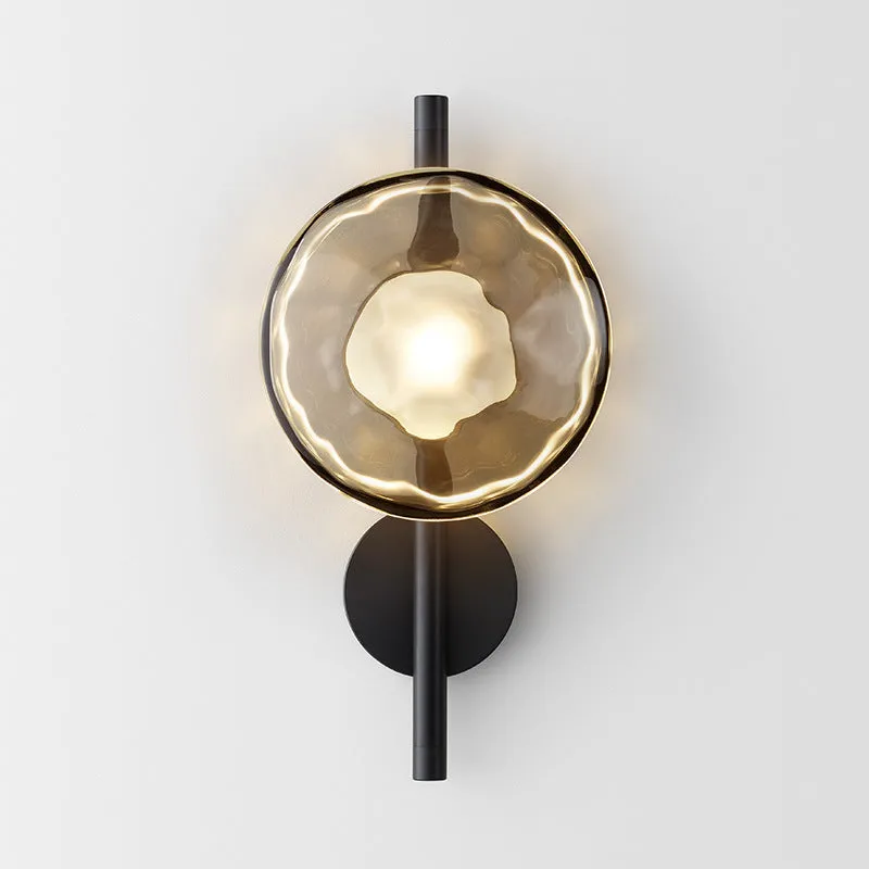 Bedside hotel glass art wall lamp with transparent lampshade and iron body on a wall