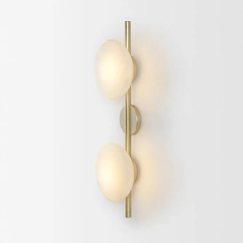 Bedside hotel glass art wall lamp with transparent lampshade and iron body on a wall