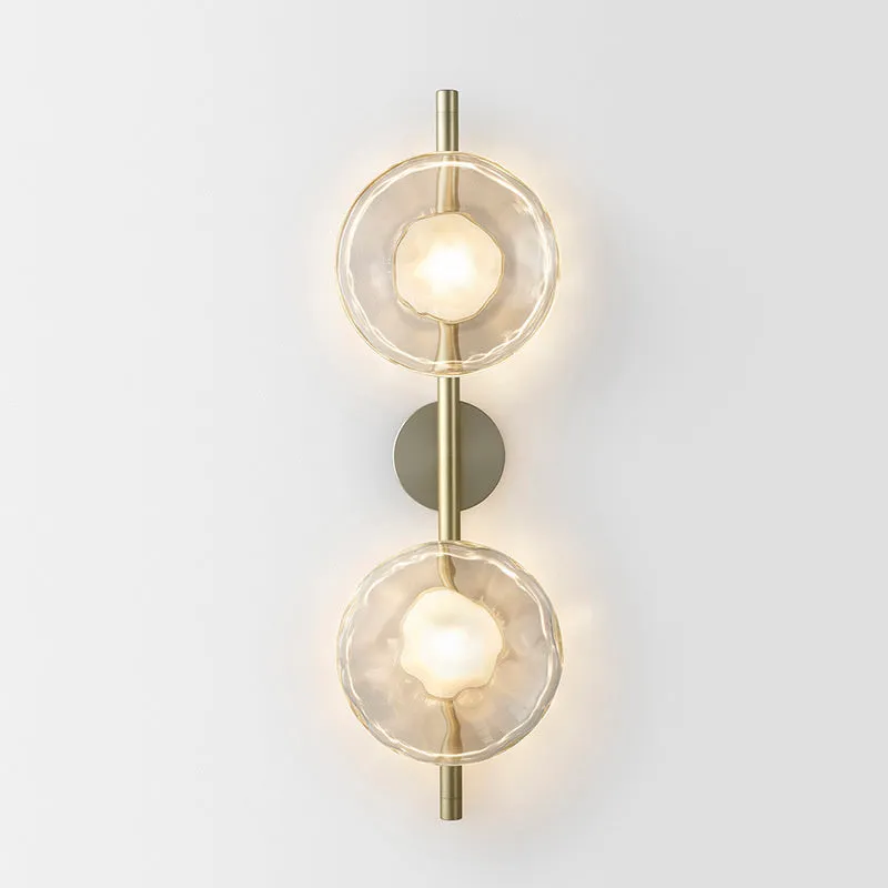 Bedside hotel glass art wall lamp with transparent lampshade and iron body on a wall