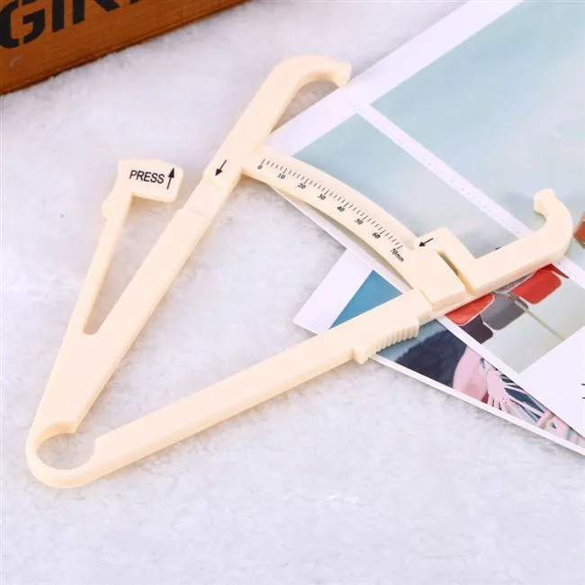 Compact acrylic fat caliper for body fat measurement, showing size and scale.