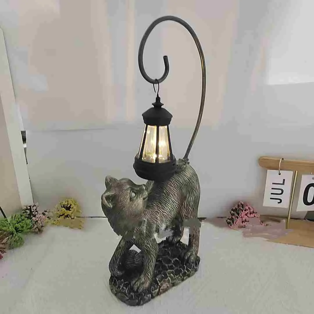 Bronze resin cat solar garden lamp on a garden path, outdoor decoration