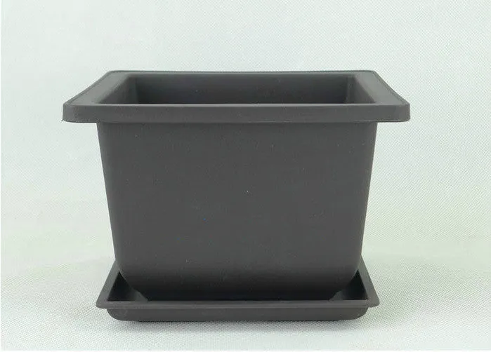 Dark brown antique-style recycled plastic flowerpot on a wooden garden table.