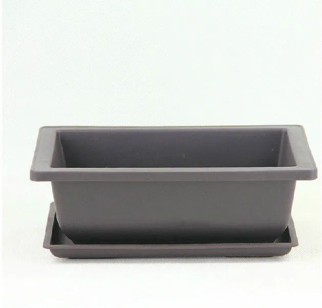 Dark brown antique-style recycled plastic flowerpot on a wooden garden table.