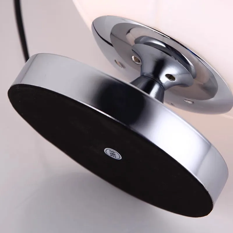 Creative football-shaped glass table lamp with dimmer switch on a desk in a modern living room