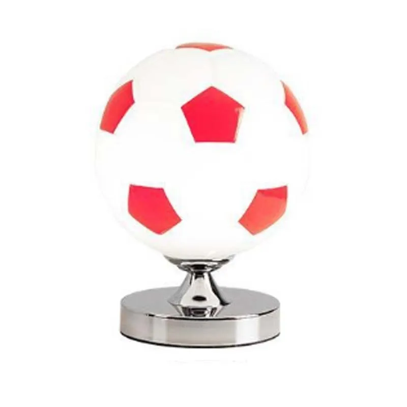 Creative football-shaped glass table lamp with dimmer switch on a desk in a modern living room