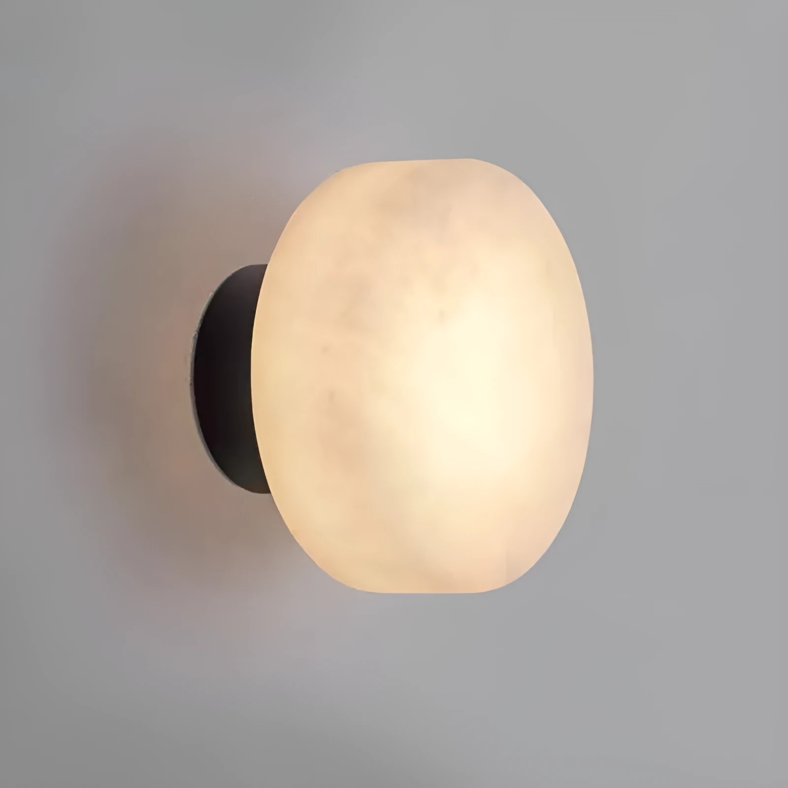Spanish natural marble round wall lamp with warm light, 130mm diameter, black finish on a bedroom wall