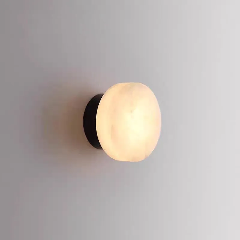 Spanish natural marble round wall lamp with warm light, 130mm diameter, black finish on a bedroom wall