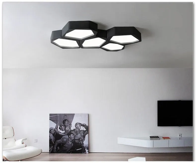 Geometric shaped iron LED light with black frame and remote control on a table.