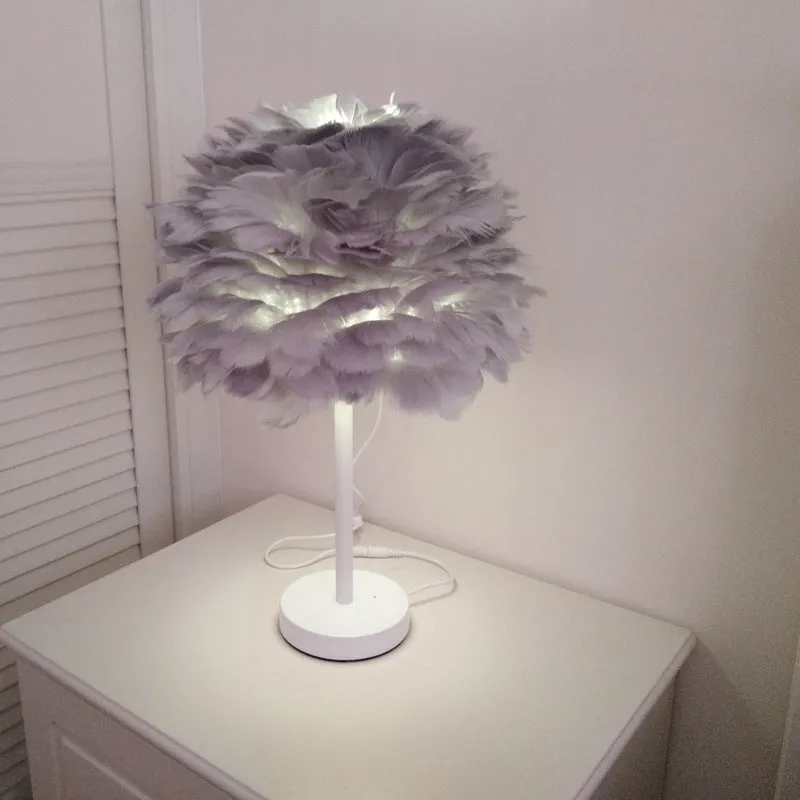White handmade feather table lamp with metal base on a wooden desk, remote control visible, 30cm diameter