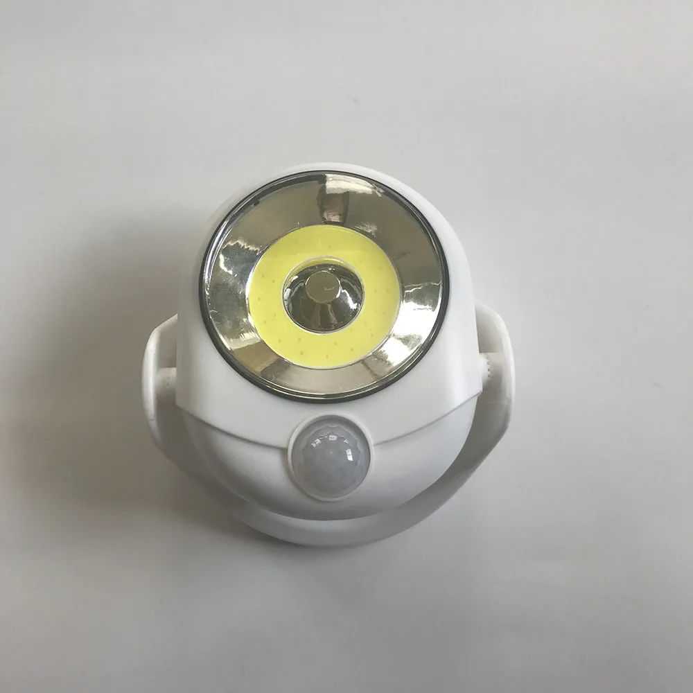 White Atomic Angel induction lamp with compact ABS housing on charging base.