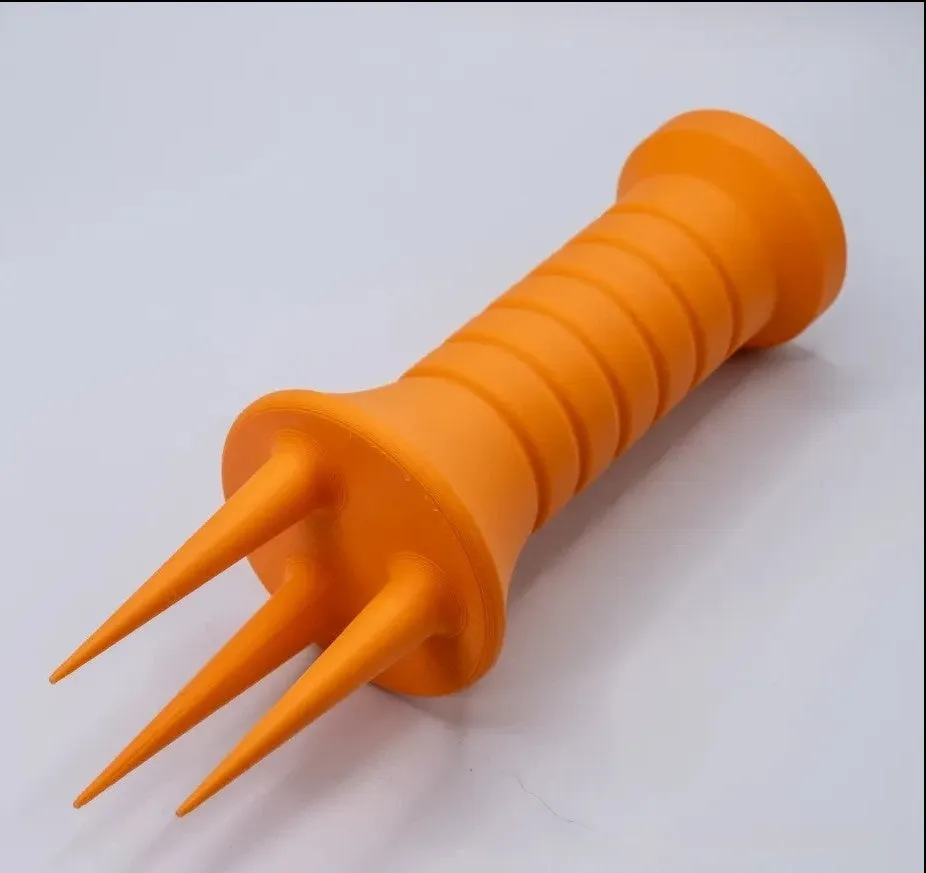 Home gardening soil aerator plastic hand tool in orange, 3.3cm x 10cm size, on soil