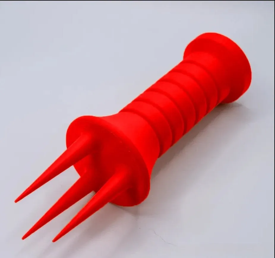 Home gardening soil aerator plastic hand tool in orange, 3.3cm x 10cm size, on soil