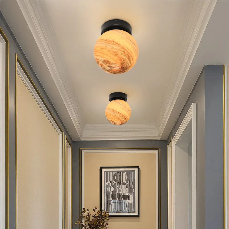 Planet Aisle bedside lamp with painted glass shade in black blue planet colour, on a table