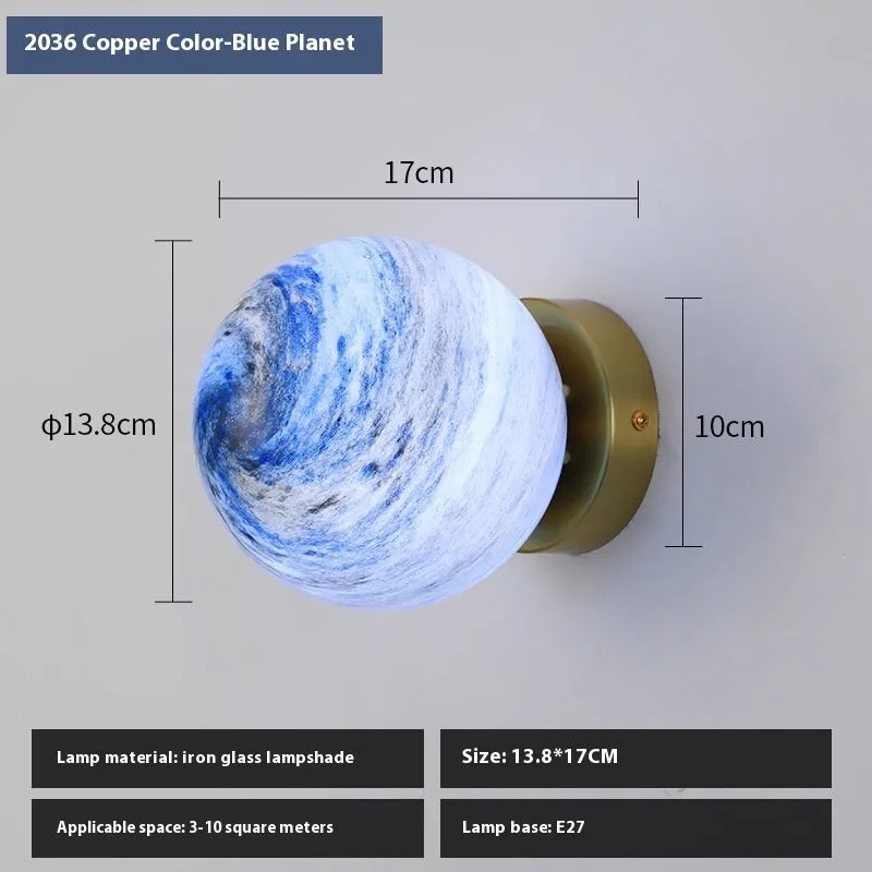Planet Aisle bedside lamp with painted glass shade in black blue planet colour, on a table