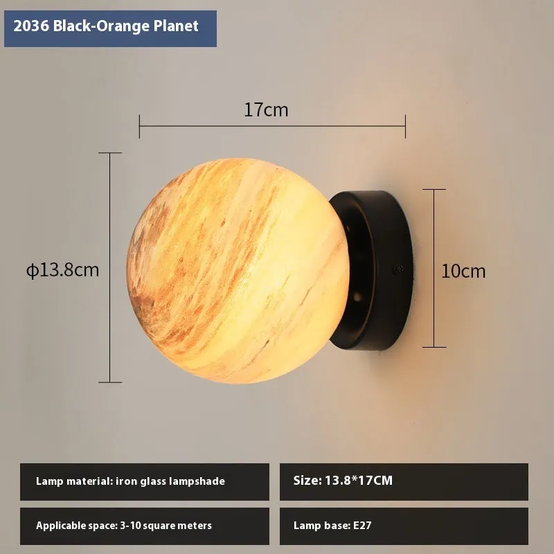 Planet Aisle bedside lamp with painted glass shade in black blue planet colour, on a table
