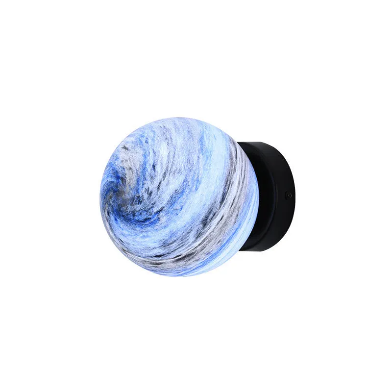 Planet Aisle bedside lamp with painted glass shade in black blue planet colour, on a table