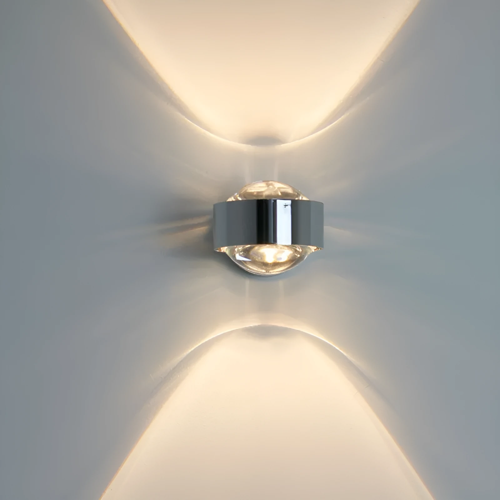 Modern small wall lamp in chrome finish for bedside or hallway lighting