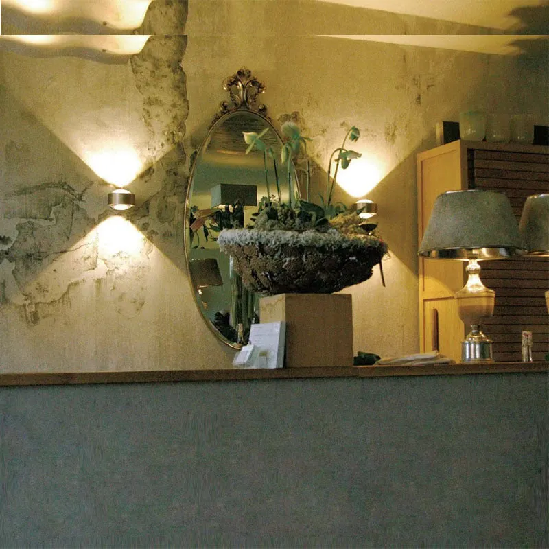 Modern small wall lamp in chrome finish for bedside or hallway lighting