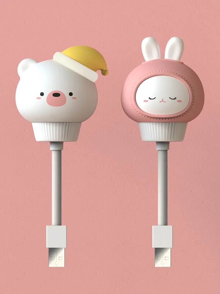 Cute cartoon animal USB night light in bear shape with soft white glow on a bedside table.