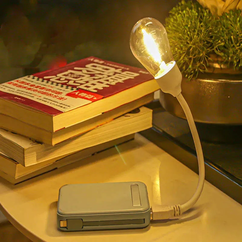 USB rechargeable folding tungsten night light with glowing S14 bulb on a table.