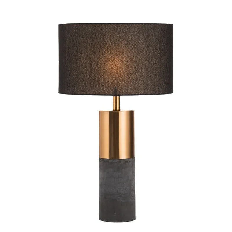 Simple designer industrial style table lamp in dark gray on a wooden desk with ambient lighting