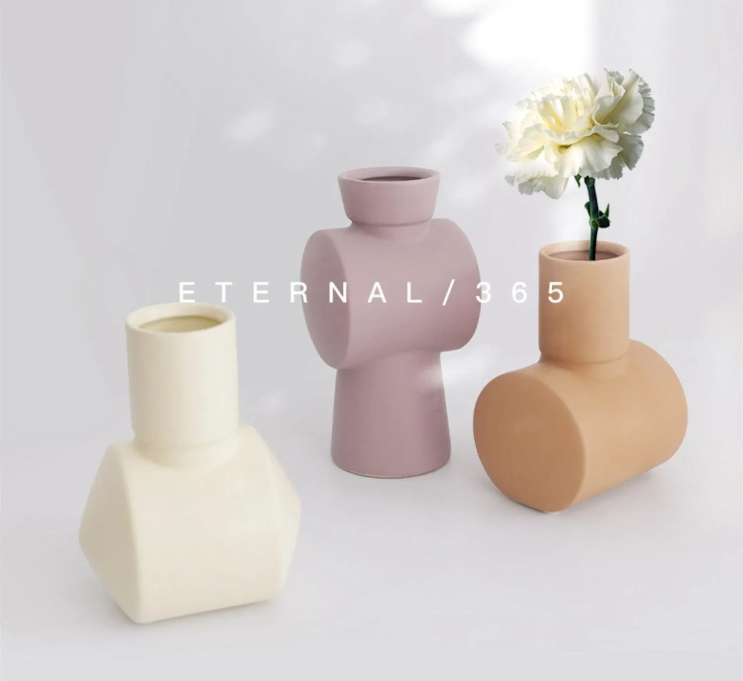 A simple hammer-textured ceramic vase in a Morandi colour on a wooden surface.