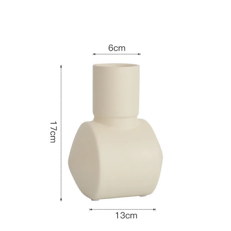 A simple hammer-textured ceramic vase in a Morandi colour on a wooden surface.