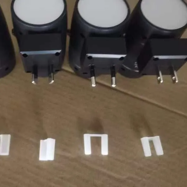 Small white induction night lamp with adjustable brightness and rotatable light head plugged into wall socket