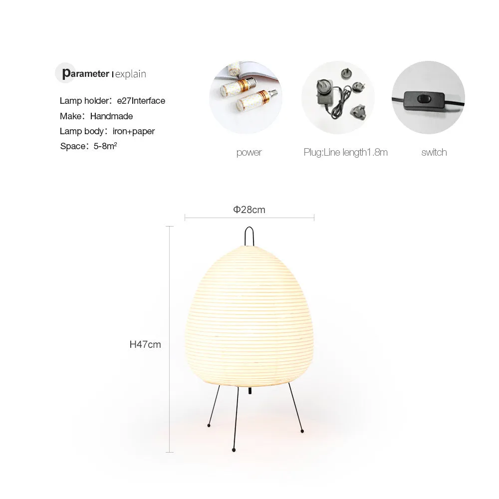 Japanese style table lamp with a white handmade rice paper lantern shade and aluminium base on a wooden table.
