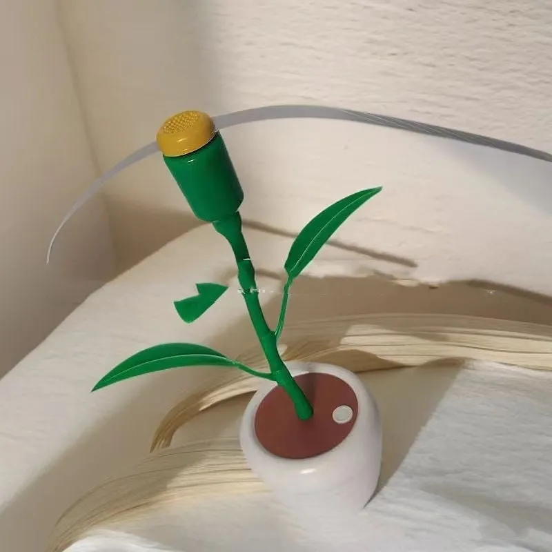 White battery fly repellent fan with curved hose and fruit-shaped design on outdoor table