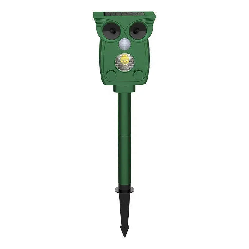 Dark green solar-powered infrared animal repeller with plastic body on grass