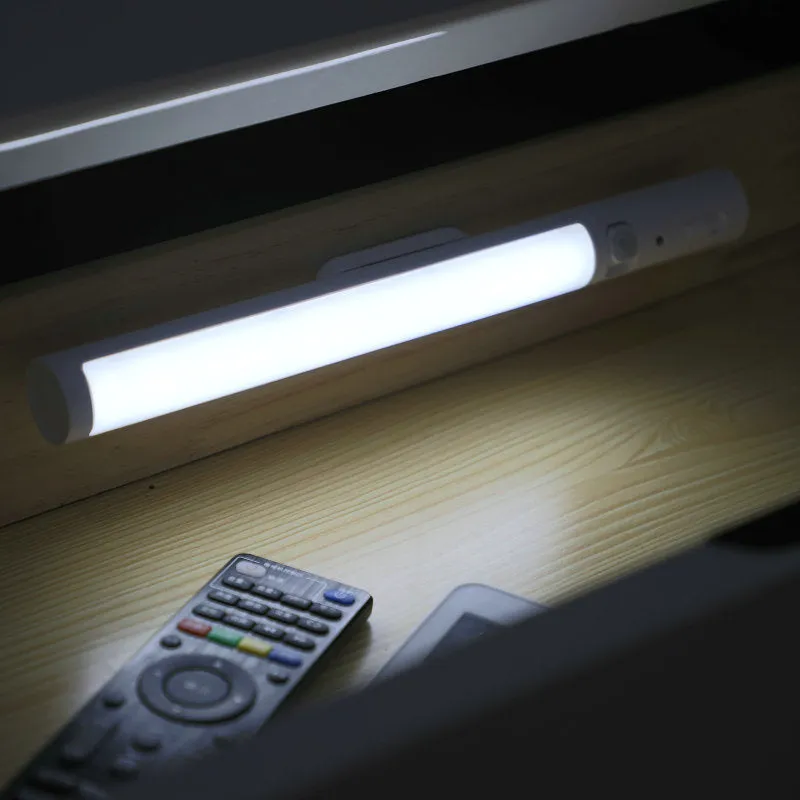 Slim white human body induction LED wall light with magnet back for under-cabinet or wardrobe installation.