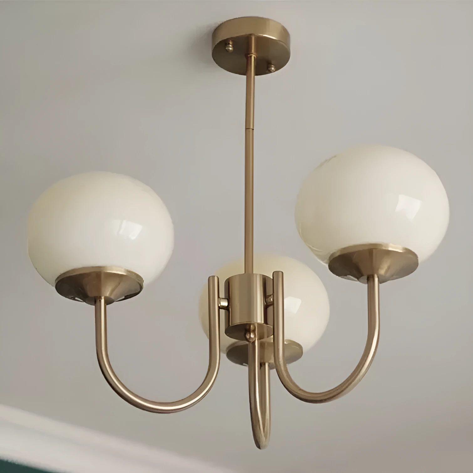 Three-head creative LED chandelier with glass lampshades and iron frame in copper pink finish for living room