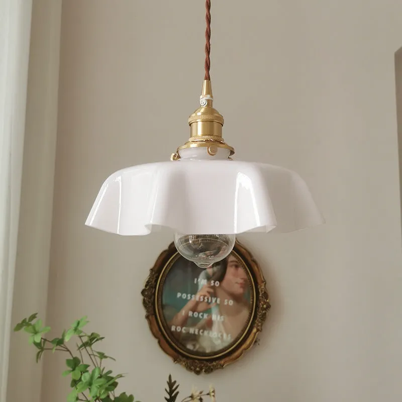 Medieval cream glass chandelier with brass flower bud design, shown with adjustable cord.