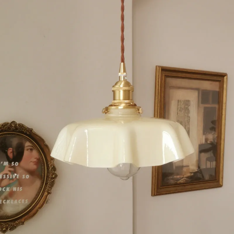 Medieval cream glass chandelier with brass flower bud design, shown with adjustable cord.