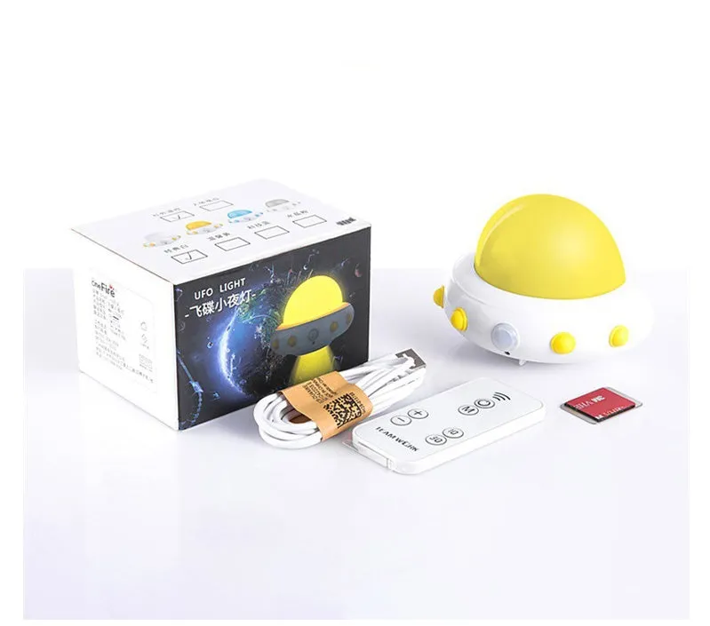 Blue UFO-shaped bedside night light with remote control on a wooden table.