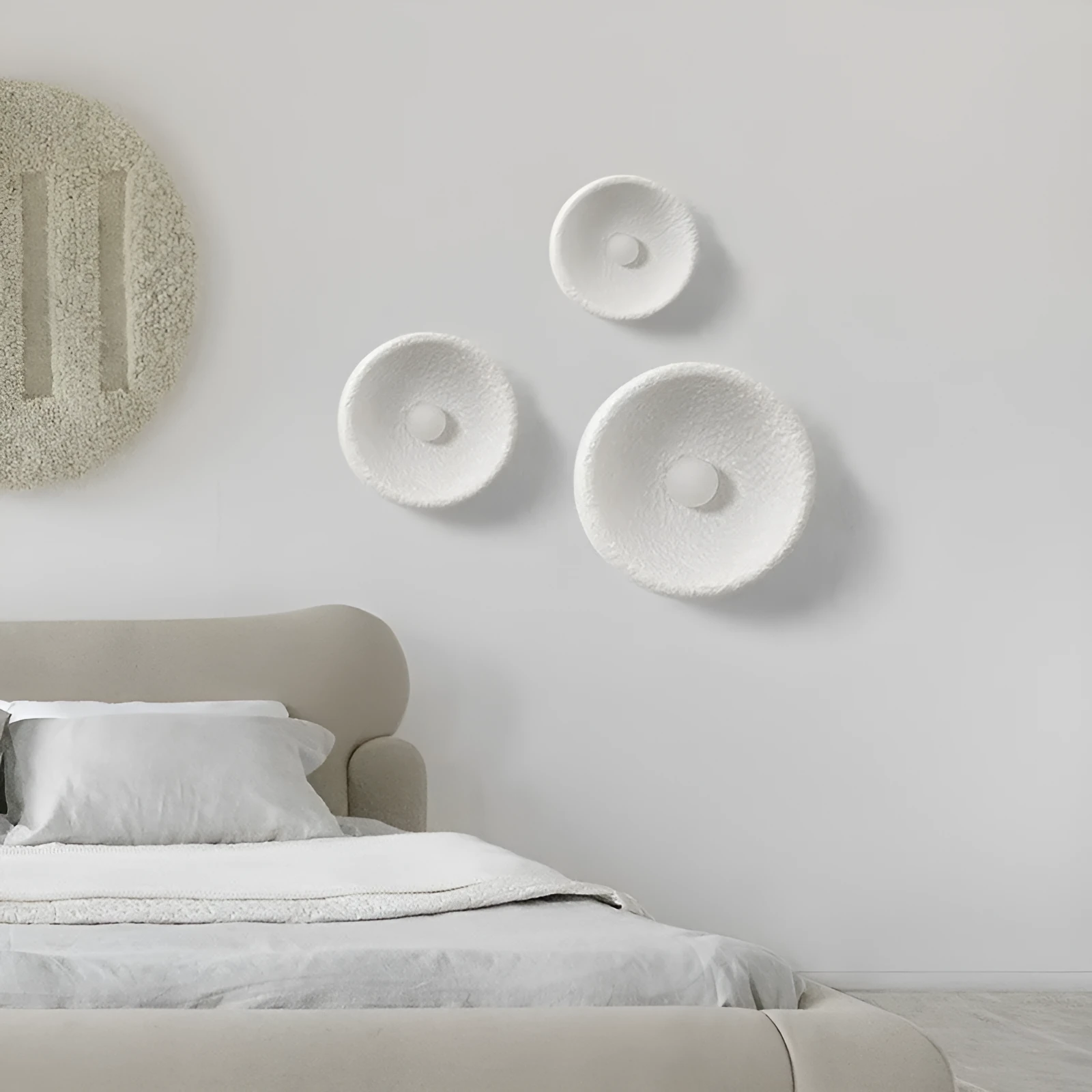 Japanese-style simple white resin wall lamp emitting warm light on a plain wall.