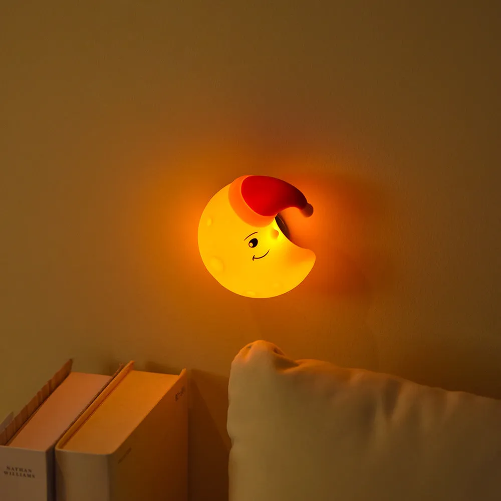 Moon XINGX Cloud silicone lamp with warm light, magnetic suction base, and cartoon design on a bedside table